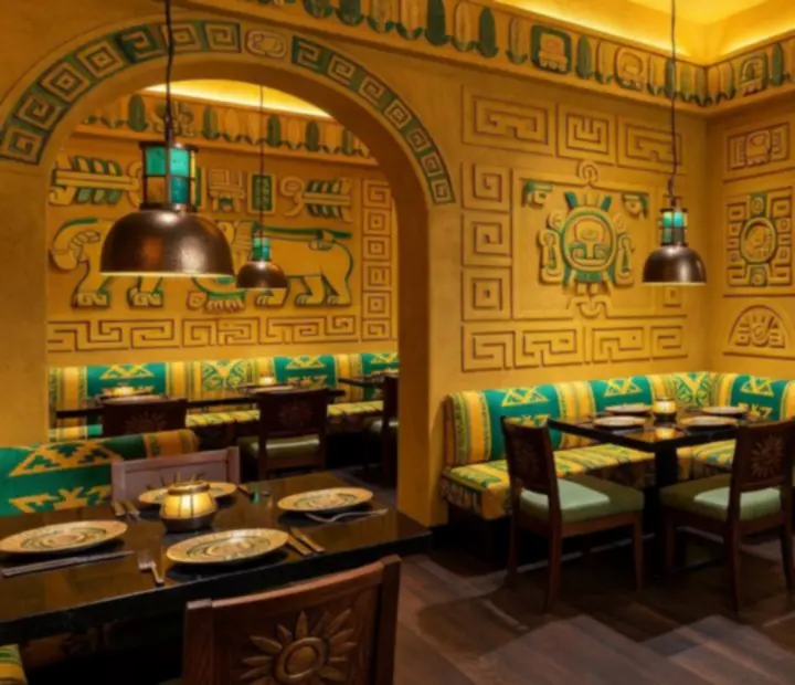 Wnętrze restauracji Veleoniras w azteckim stylu z eleganckimi stołami i nastrojowym oświetleniem